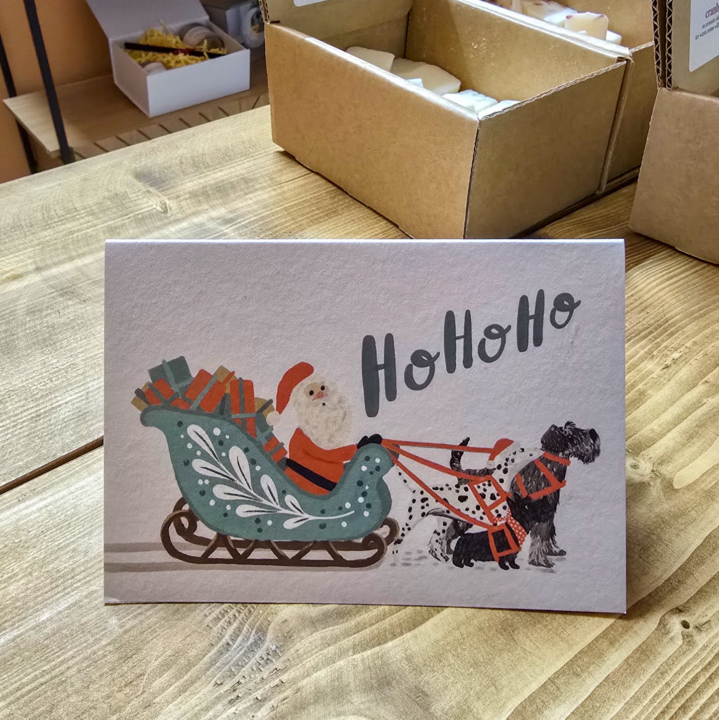 Send holiday cheer with the Sleigh & Dogs Ho Ho Ho Christmas card. This festive card features a delightful illustration of a sleigh and dogs, with the playful phrase "Ho Ho Ho" written across the front.